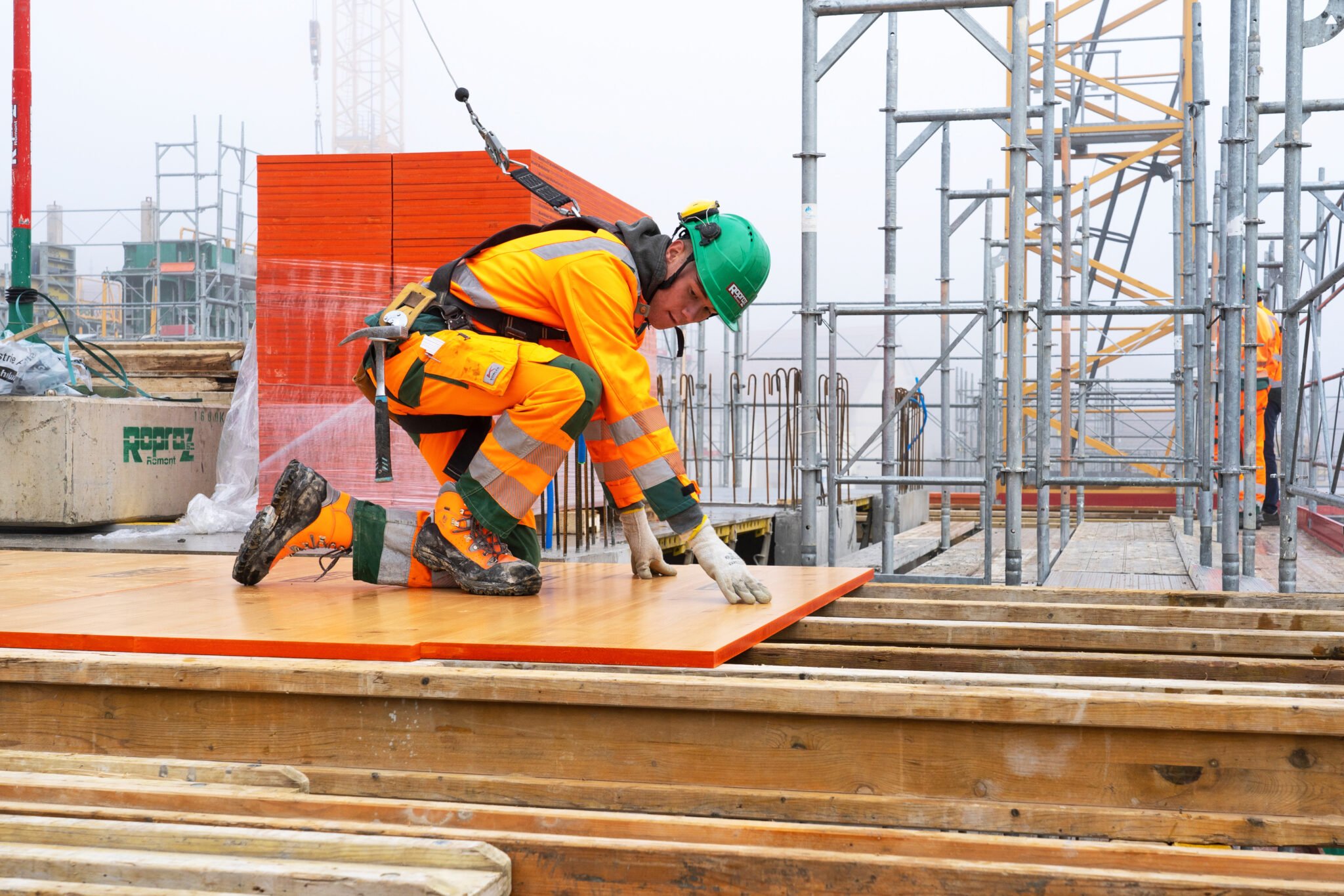 Korrekt gesicherter Bauarbeiter bringt Schalltafeln an