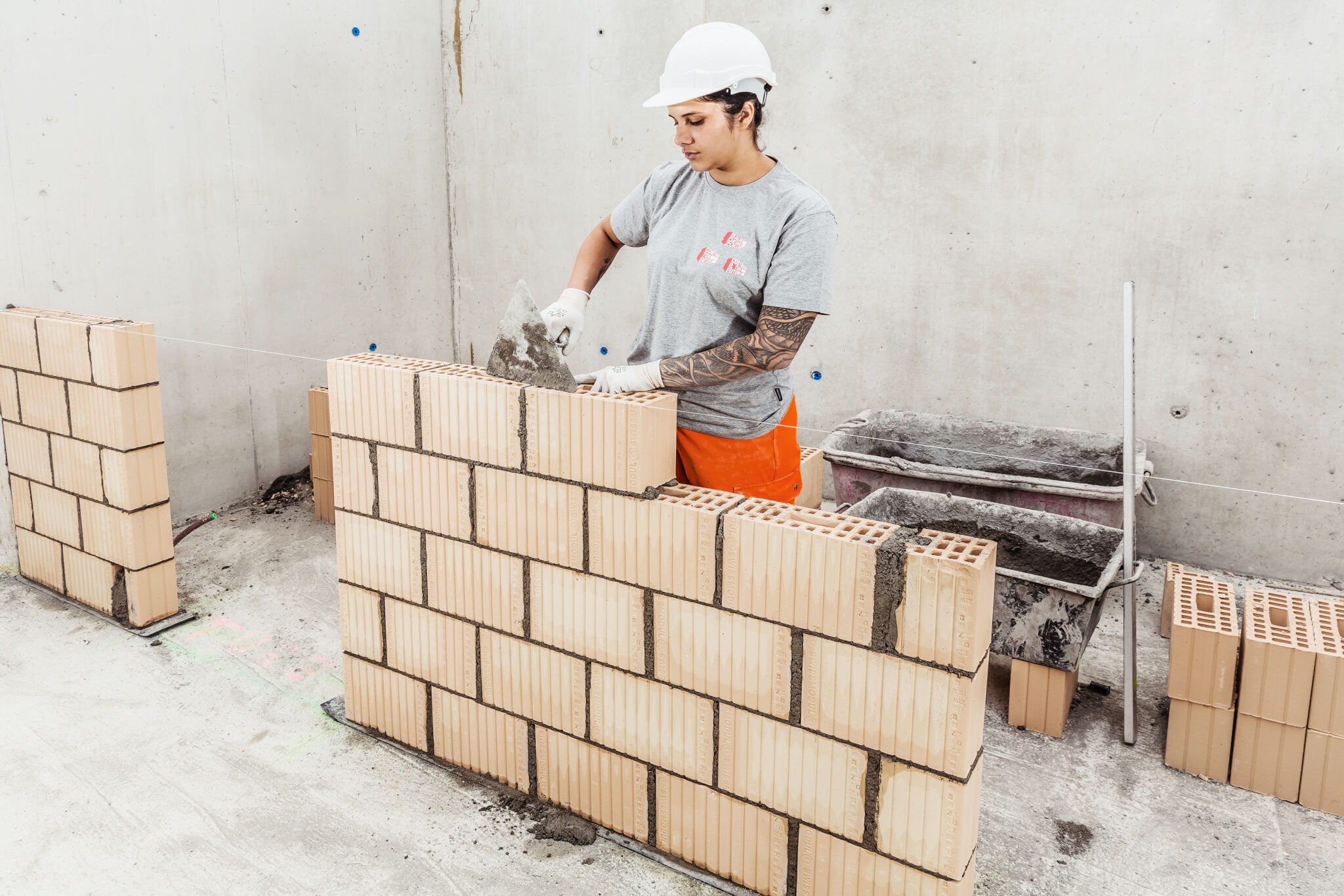 Lernende Maurerin beim Mauern