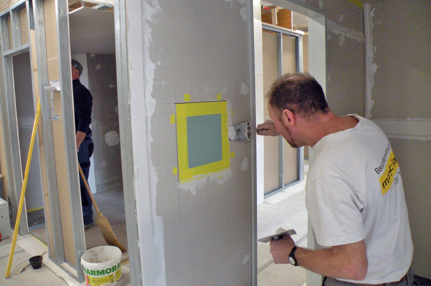 Maurer klebt Leichtbauwand ab